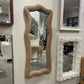 Various decorative mirrors with unique frames on a wall.