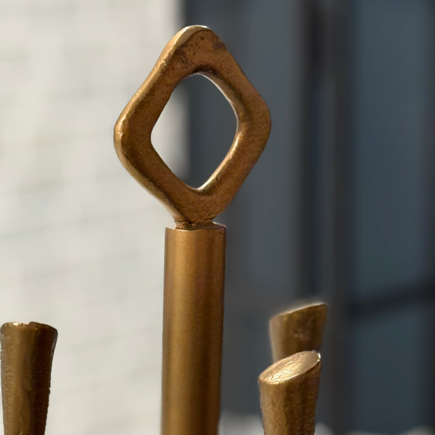 Bronze sculpture with geometric design on a blurred background