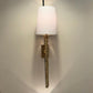 Wall-mounted lamp with decorative base on a plain wall