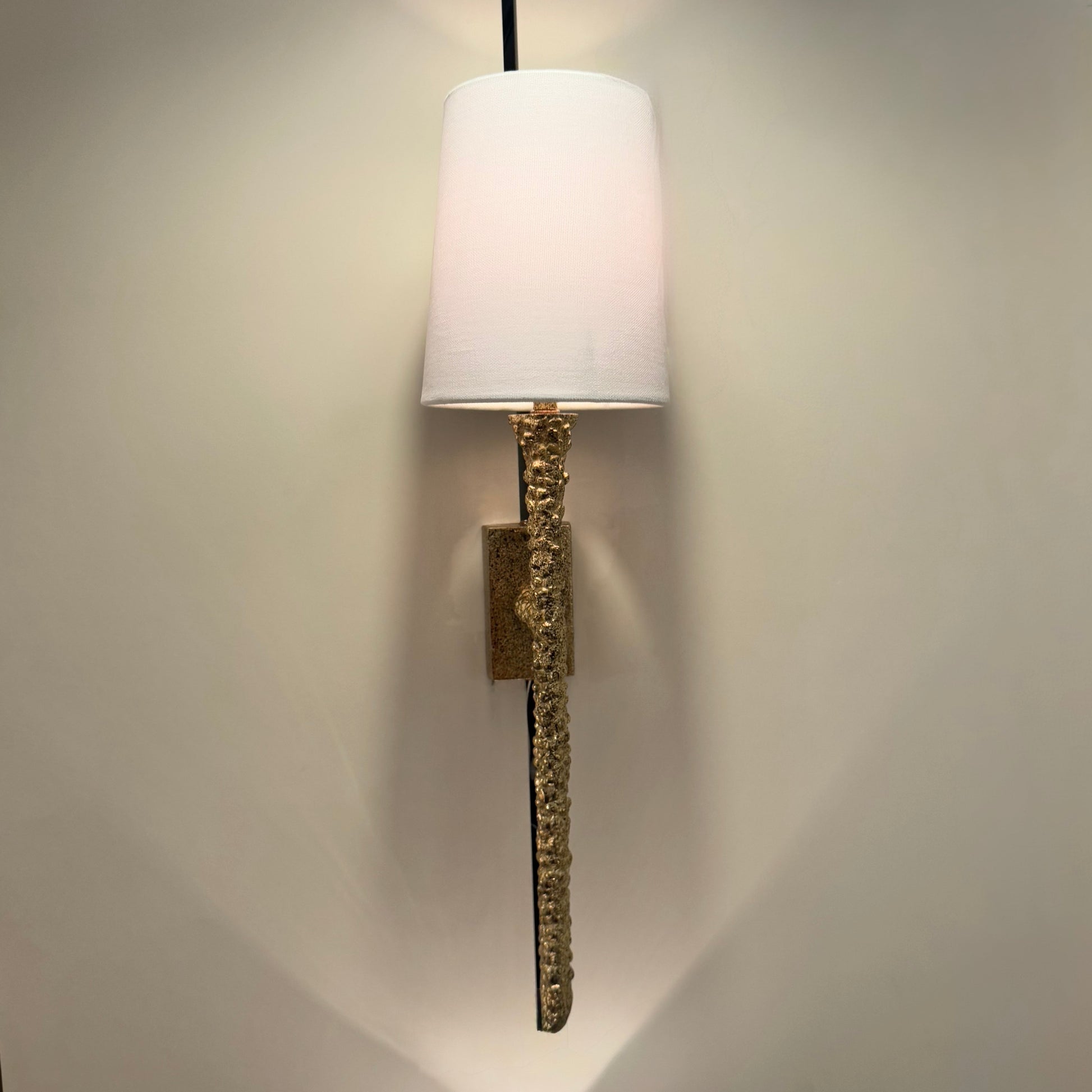 Wall-mounted lamp with decorative base on a plain wall