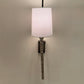 Wall-mounted lamp with a white shade on a plain wall