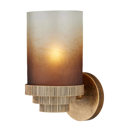 A modern cylindrical wall sconce with a frosted glass shade featuring a warm gradient from cream to brown, mounted on a textured gold metal base with a fluted circular band.