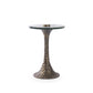 Small round table with a glass top and textured bronze base on a white background