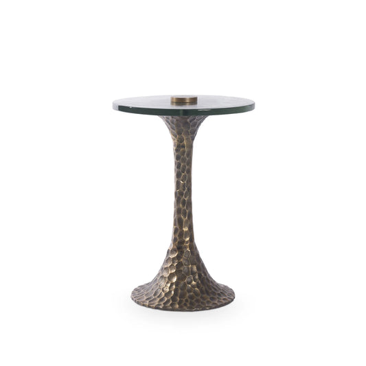 Small round table with a glass top and textured bronze base on a white background