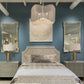 Decorative bedroom with patterned headboard, mirrors, and chandelier.