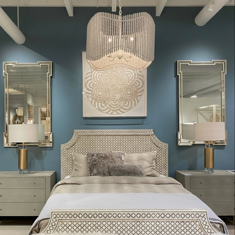 Decorative bedroom with patterned headboard, mirrors, and chandelier.