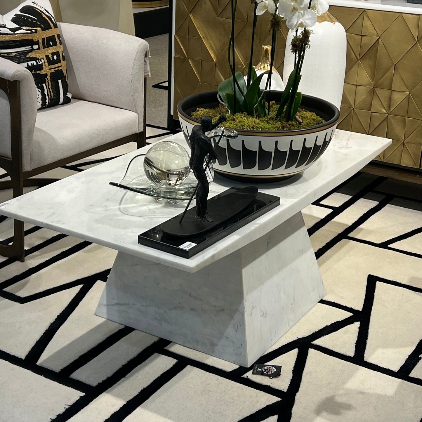 Modern living room with a marble coffee table, decorative plant, and stylish decor.