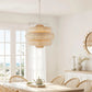 Dining room with wooden table and chairs, wicker pendant light, and window view.