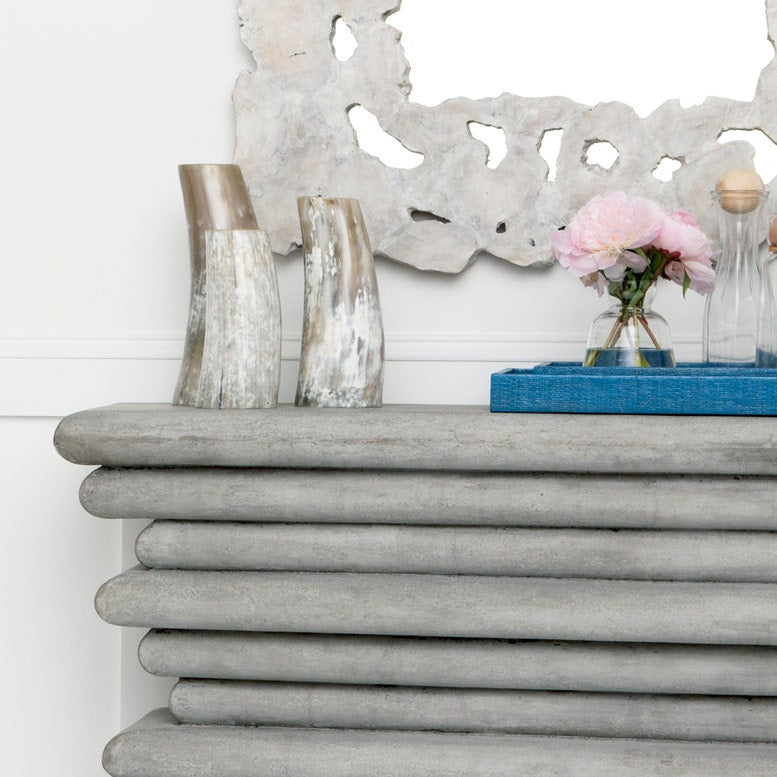 Decorative shelf with vases and flowers against a white wall