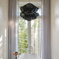 Bathroom with a freestanding white bathtub, black chandelier, and large windows with curtains.