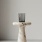 Marble pedestal with a black rectangular object on a plain background