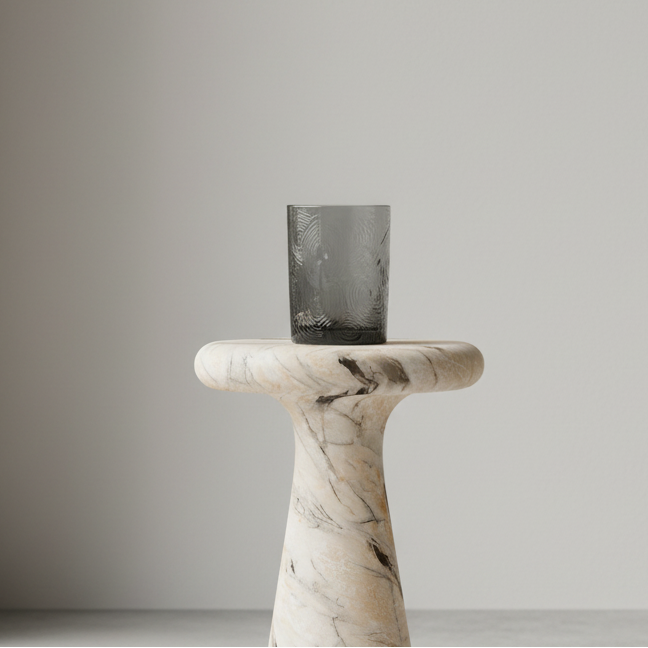 Marble pedestal with a black rectangular object on a plain background