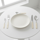 White ceramic plate with silverware on a white surface