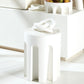 White abstract sculpture on a white surface with a blurred background