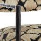 Close-up of a chair leg with patterned fabric background