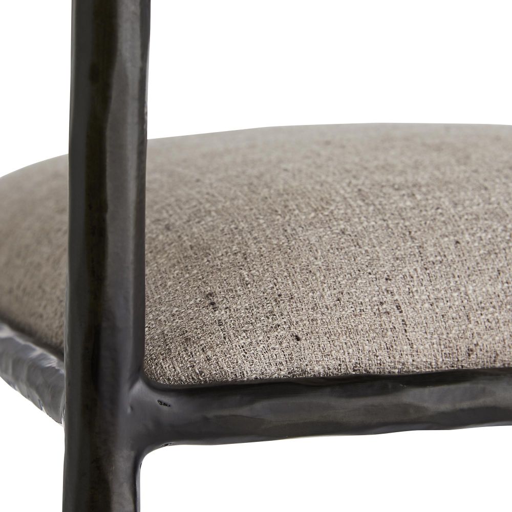 Close-up of a chair with a textured gray cushion and black metal frame.