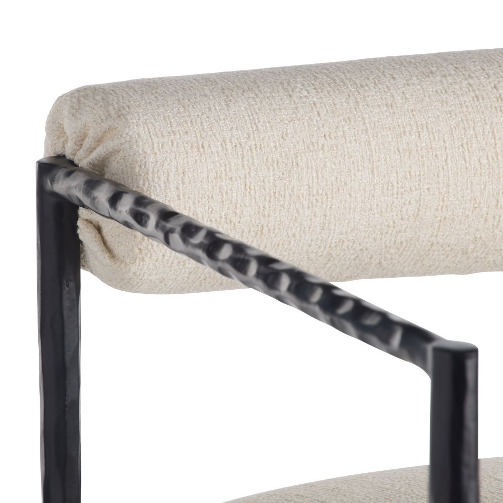 Close-up of a chair with a textured beige cushion and black metal frame on a white background