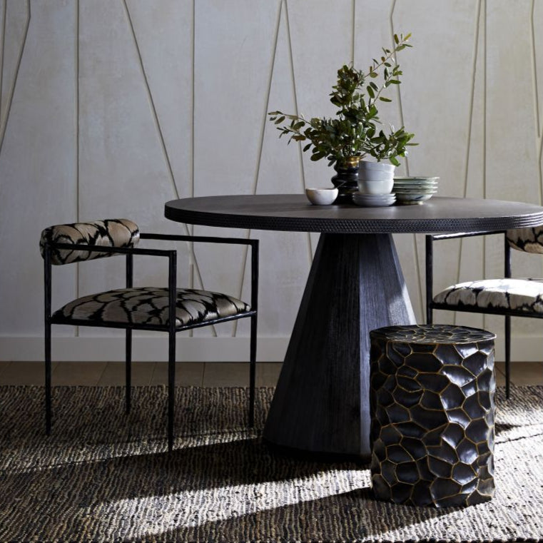 Dining room with a dark wooden table, chairs, and a woven pendant light.