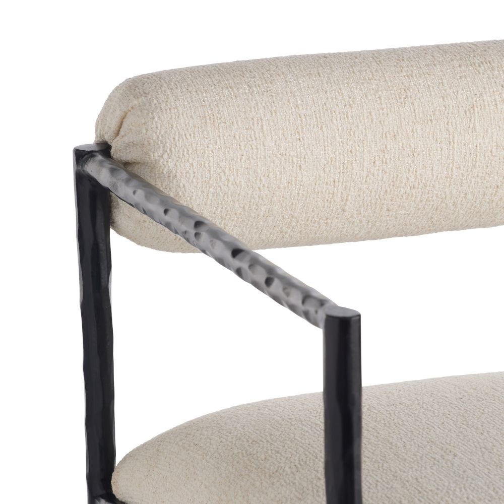 Close-up of a chair with a black metal frame and beige cushioned seat and backrest.