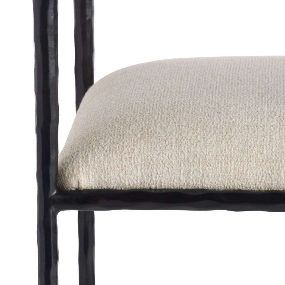 Close-up of a chair with a textured beige seat and black metal frame on a white background