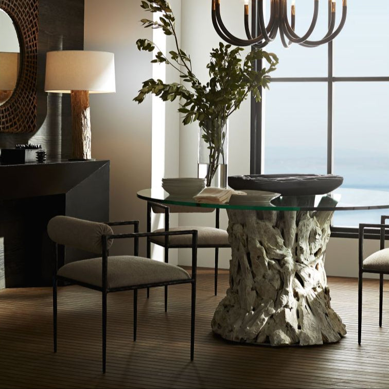 Modern dining room with a glass table, chairs, and decorative elements.