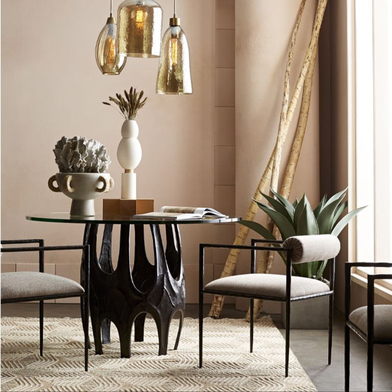 Modern dining room with a black round table and chairs, featuring decorative elements.