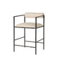 Bar stool with black metal frame and beige cushioned seat on a white background