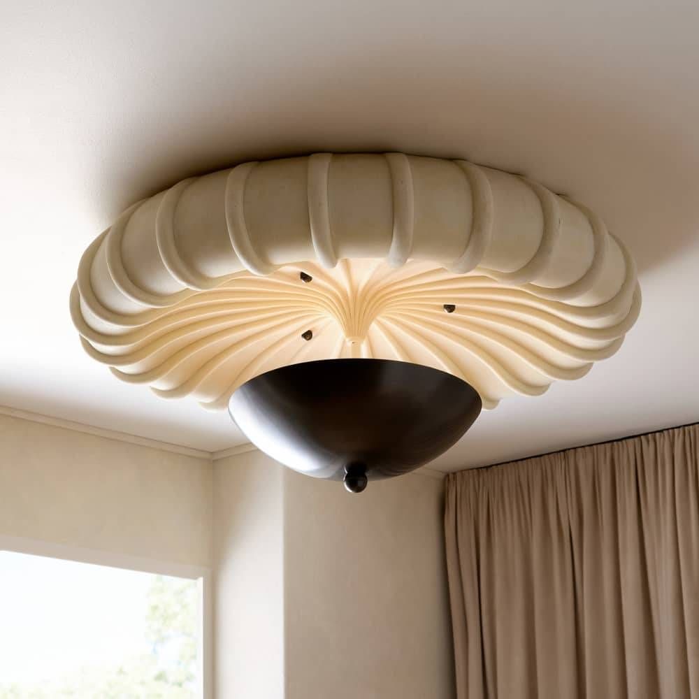 Ceiling light fixture with decorative design in a room with curtains and window.