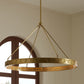 Gold chandelier hanging in a room with a window in the background