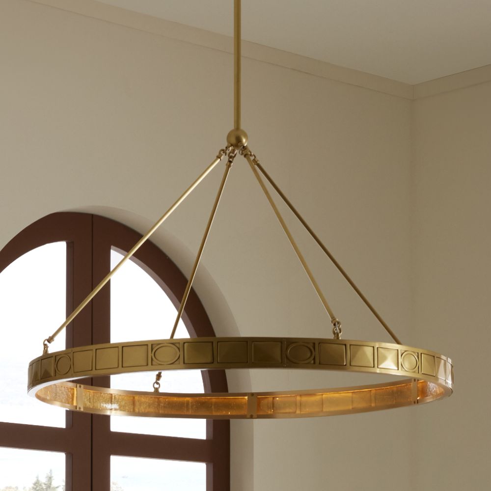 Gold chandelier hanging in a room with a window in the background