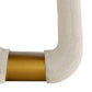 Close-up of a chair arm with beige fabric and gold metal accent on a white background