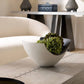 Decorative bowl with greenery on a coffee table in a modern living room.