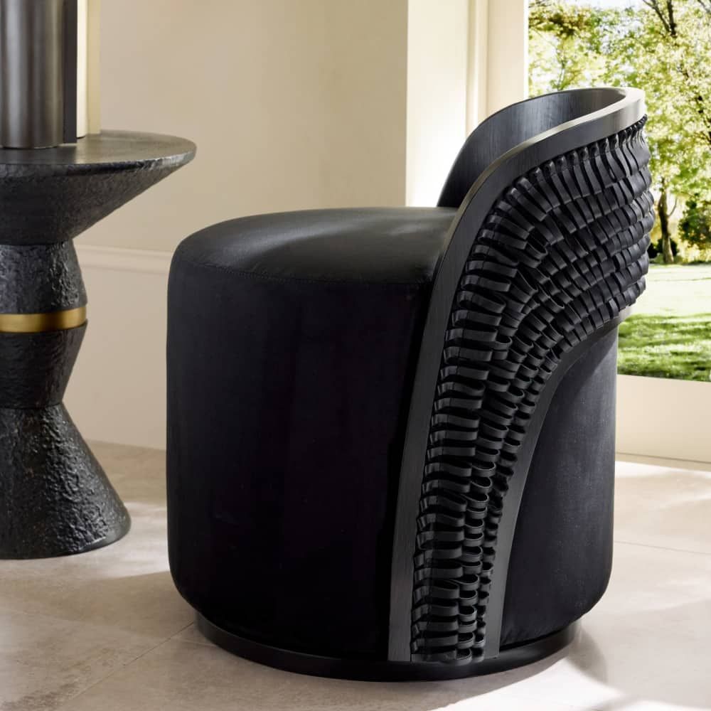 Modern black chair with unique design in a room with a window showing greenery