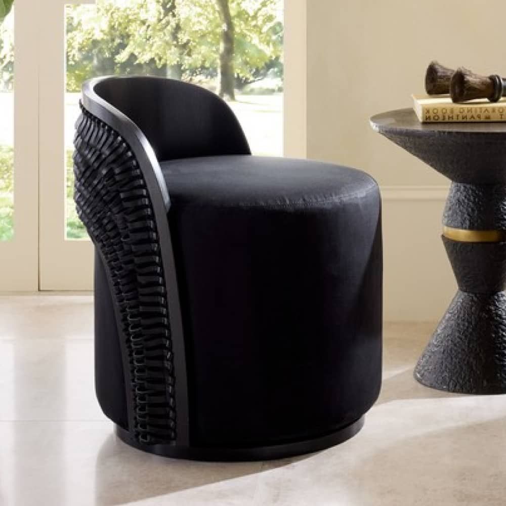 Black swivel chair in a room with a window and side table.