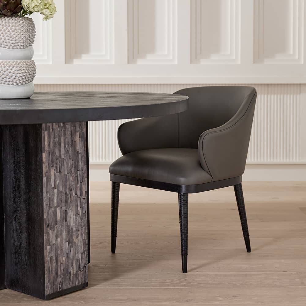Gray leather armchair with black legs styled in a room