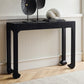 Black console table with decorative items against a white wall.