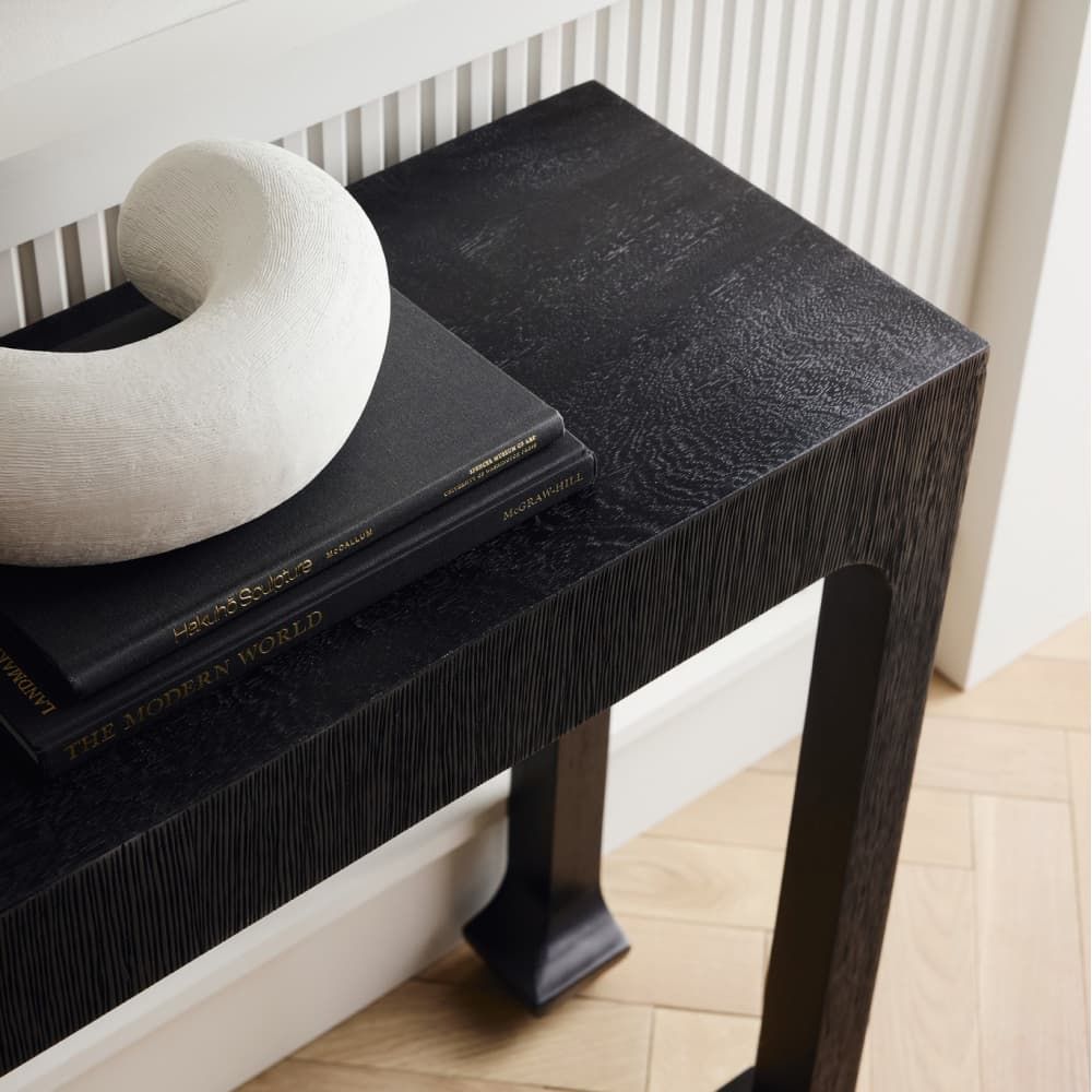 Black marble table with a book and decorative object in a minimalistic setting