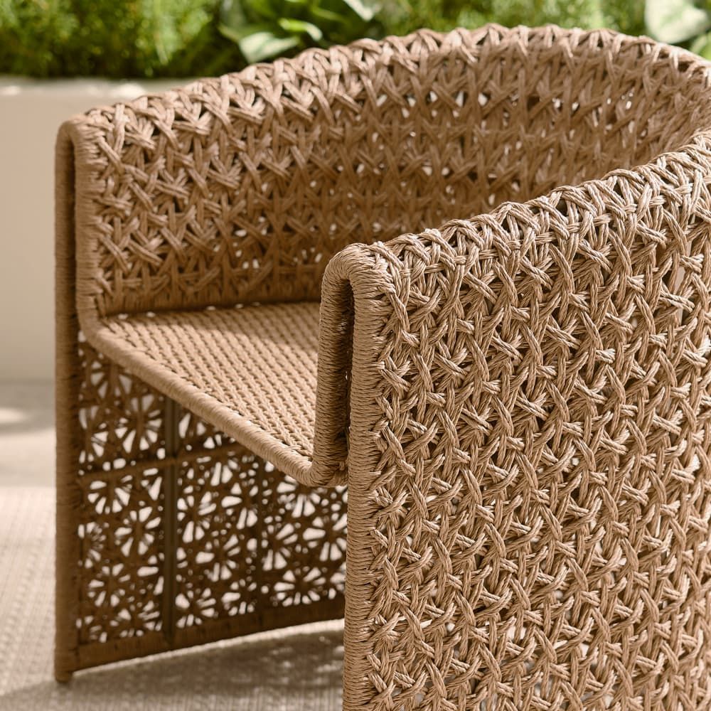 Woven outdoor chair with intricate pattern on a blurred natural background