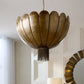 Gold chandelier hanging in a room with a mirror and candle