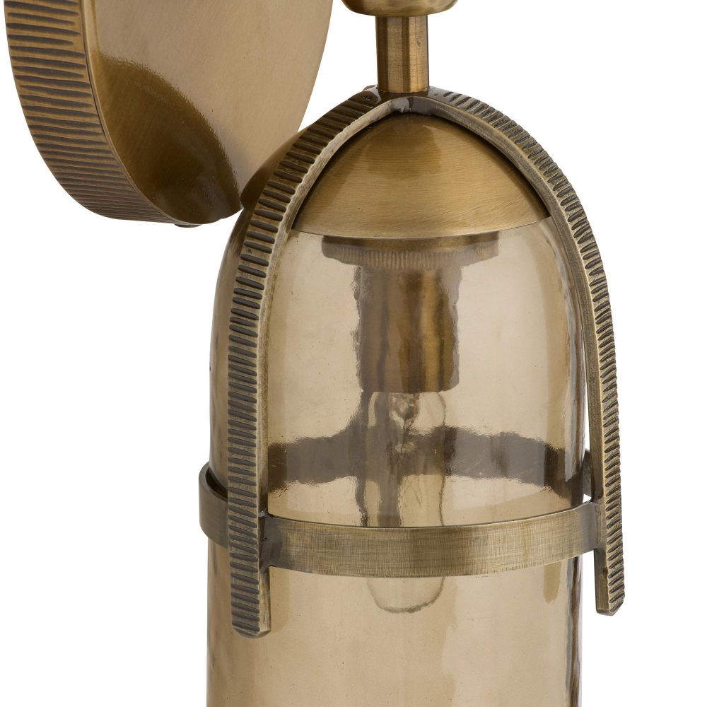 Vintage-style brass wall sconce with clear glass shade on a white background