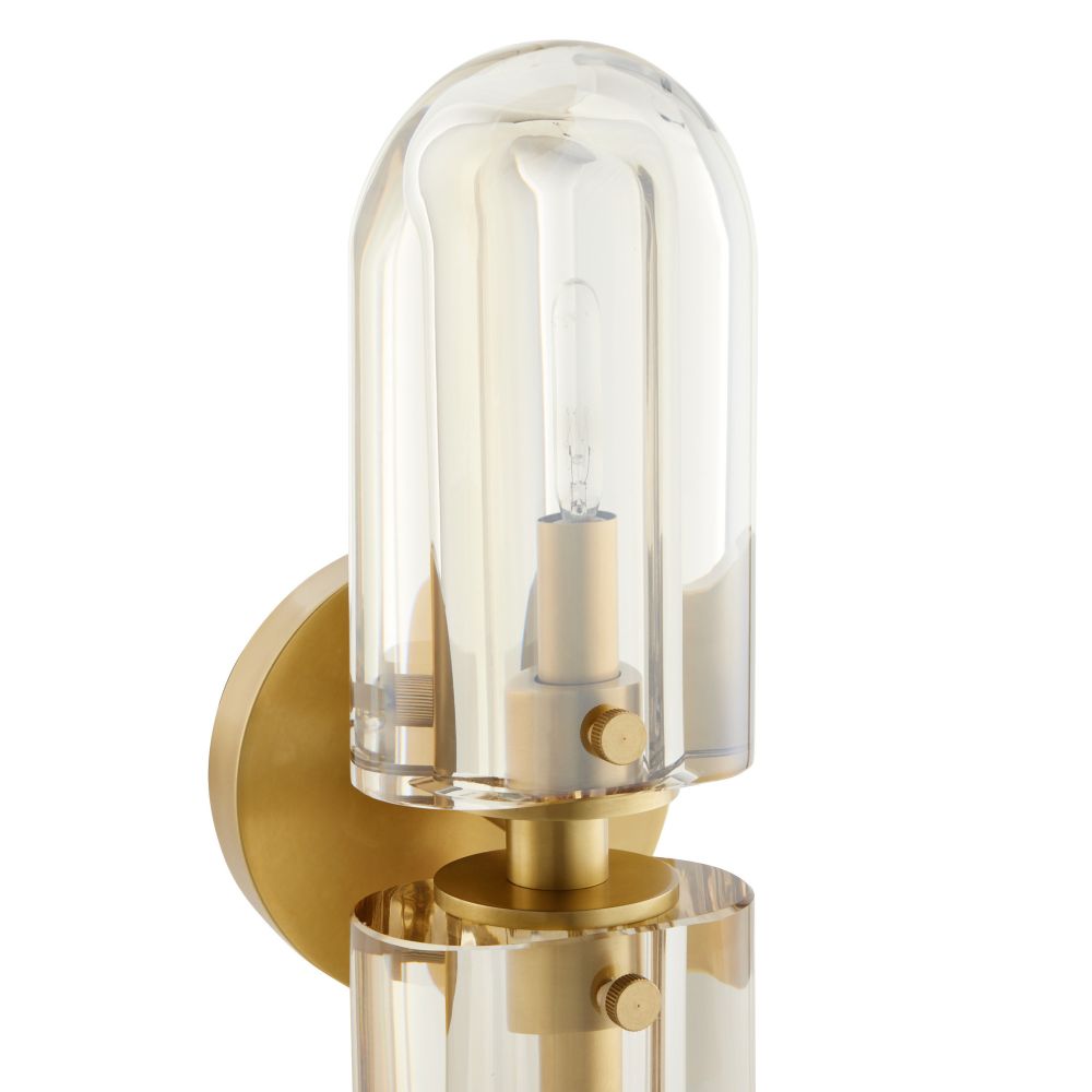 Wall-mounted light fixture with clear glass shade and gold metal base on a white background