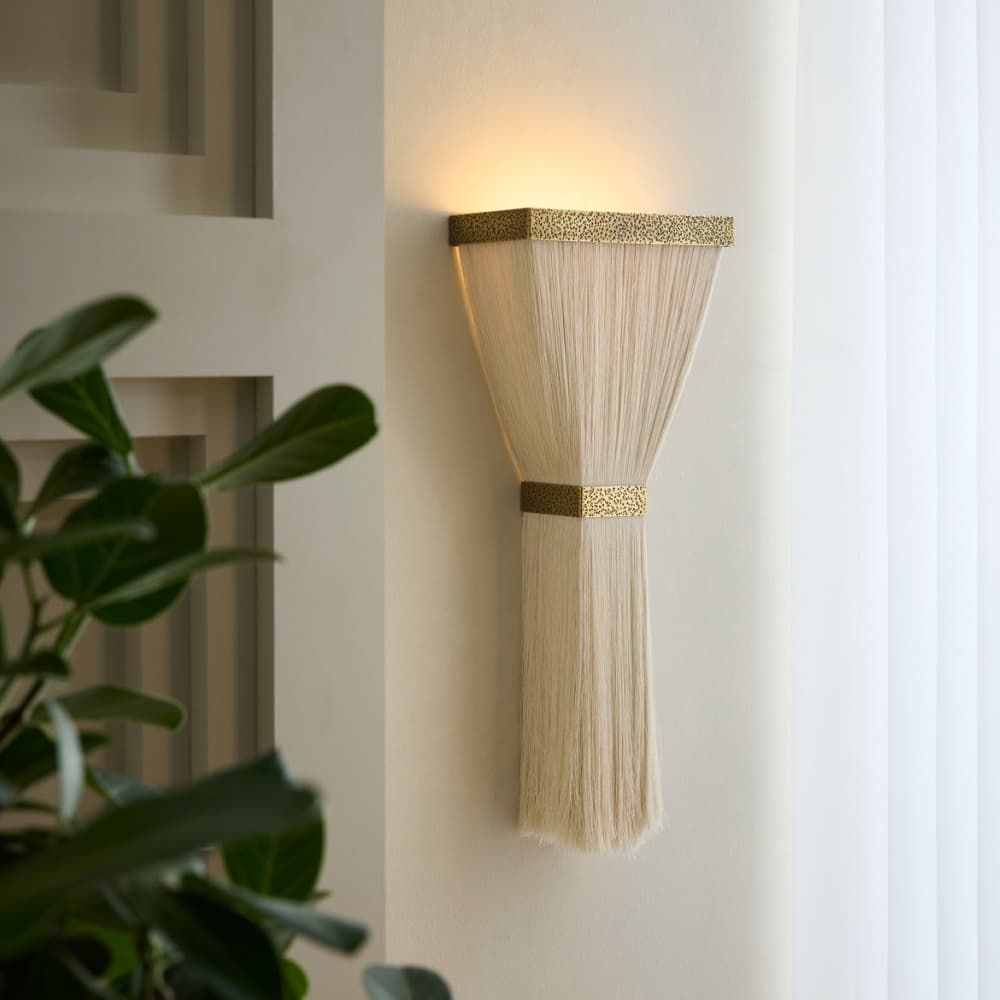 Decorative wall light fixture with gold accents on a neutral wall.