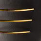 Three gold bracelets on a black leather surface