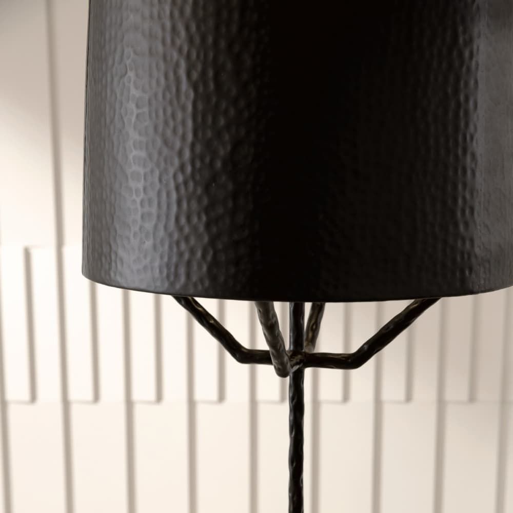 Close-up of a black textured lampshade on a white paneled wall background