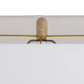 Decorative lamp with a cylindrical beige shade and gold arm on a white background