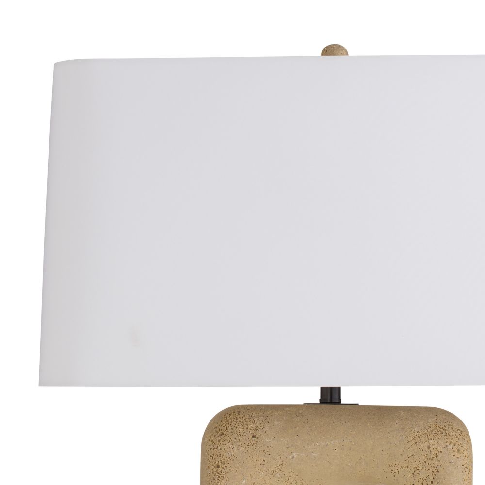 Table lamp with a white shade and textured beige base on a white background