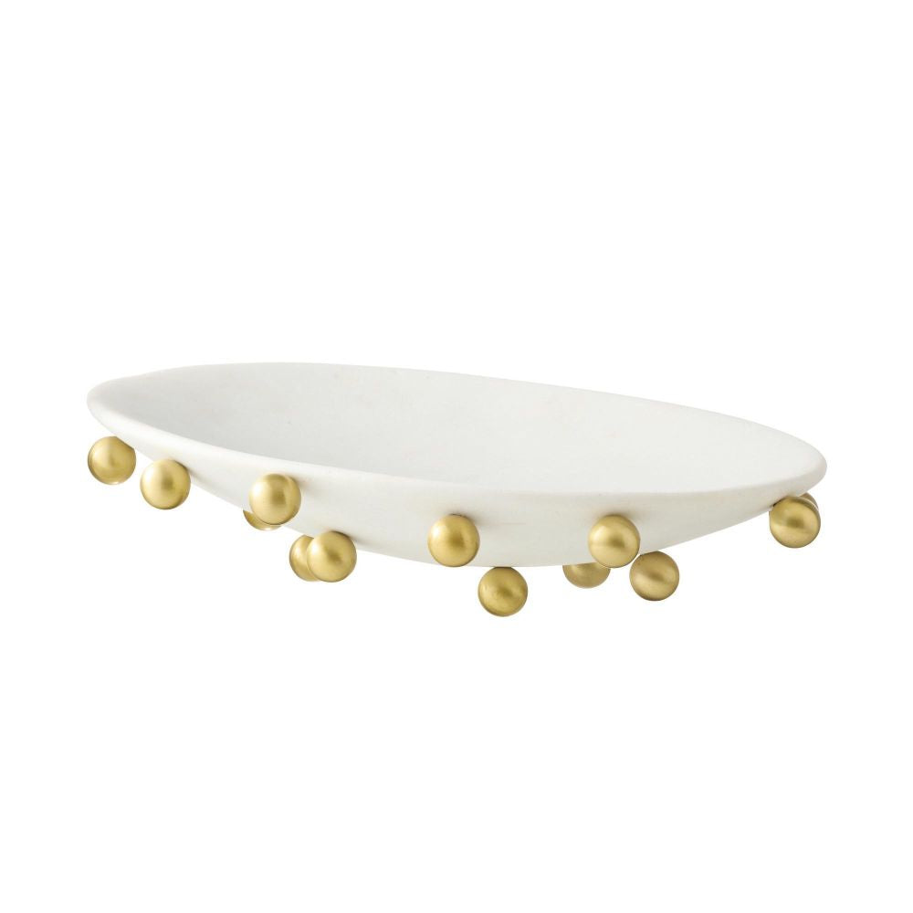 White oval tray with gold spherical accents on a white background