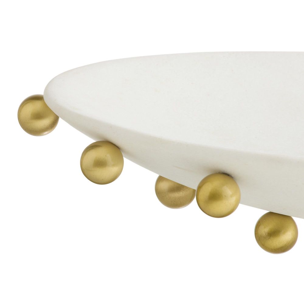 White dish with gold spherical accents on a white background
