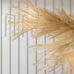 Close-up of a decorative gold plant against a white paneled wall
