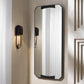 Wall-mounted mirror with black frame on a neutral wall